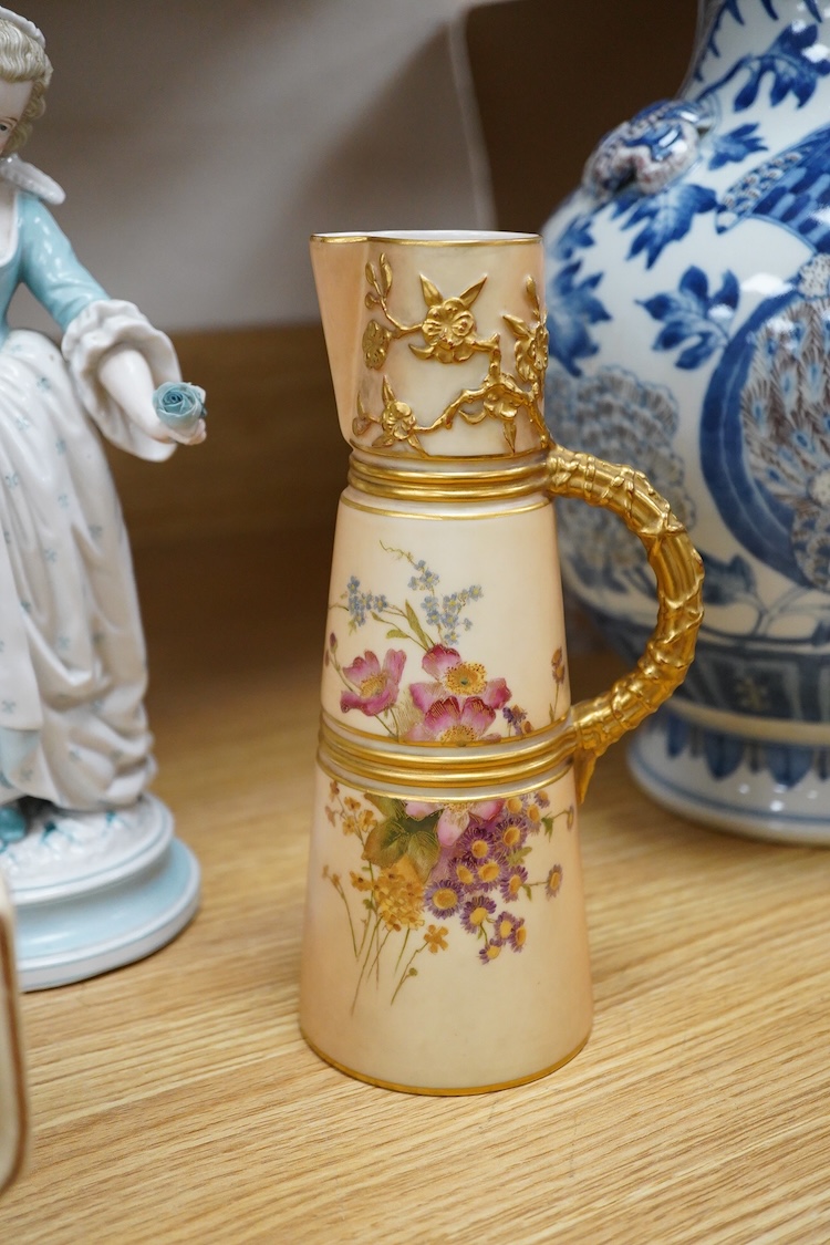 Sundry porcelain comprising three German figures, a Royal Worcester blush ivory ewer and a mug, together with a blue wine glass, largest 26cm high